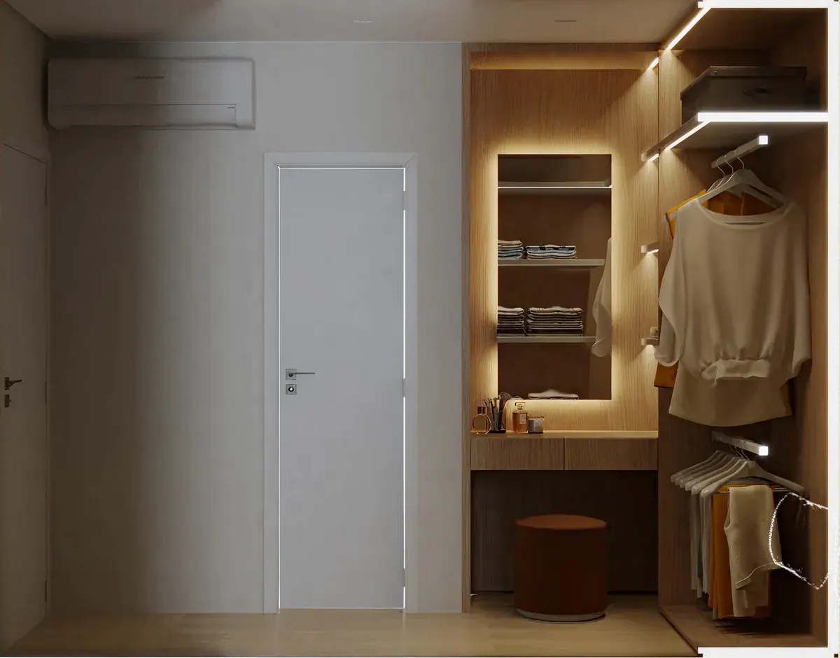 Closet iluminado com penteadeira, cabideiro e puff ao lado da porta do quarto