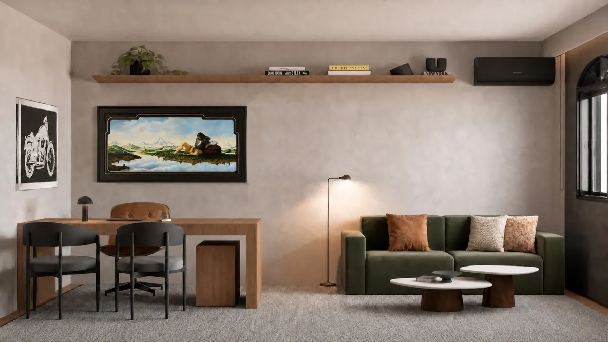 Parede com mesa de trabalho, cadeiras, sofá verde e prateleira longa sob o quadro de paisagem